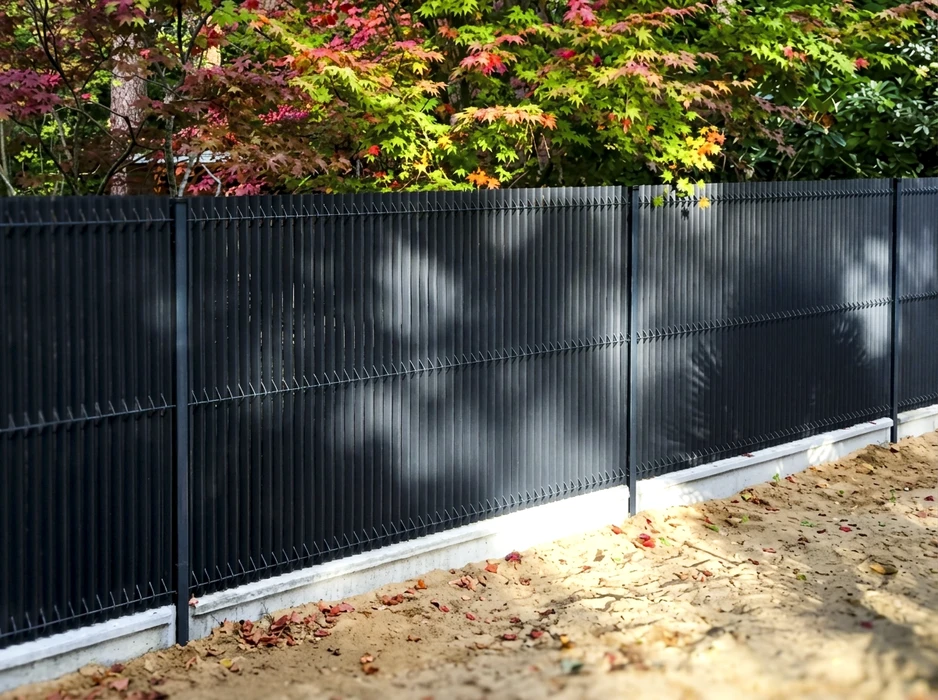 Clôture rigide en panneaux de grillage soudé anthracite, installée sur longrine béton préfabriquée