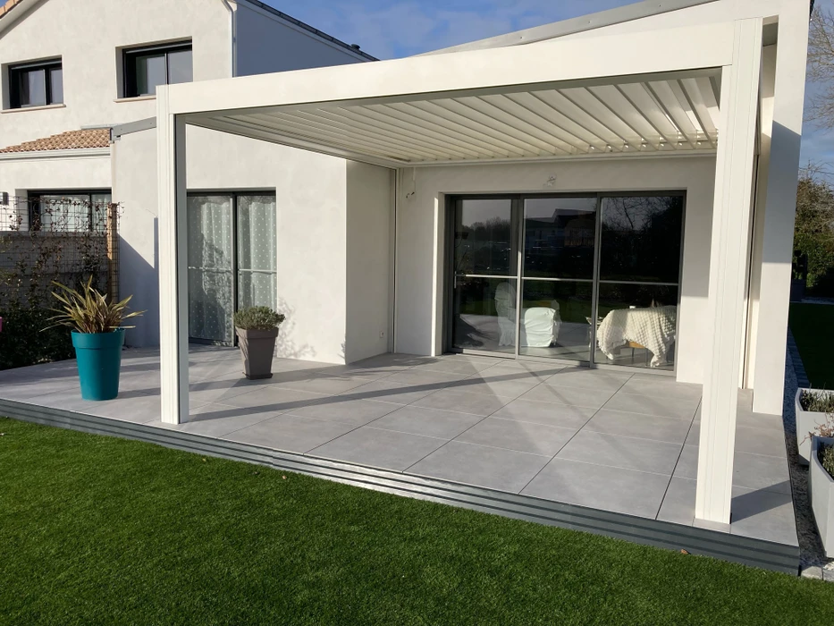 Jardin privatif au crépuscule avec abri de piscine bas télescopique en polycarbonate transparent, structure aluminium anthracite